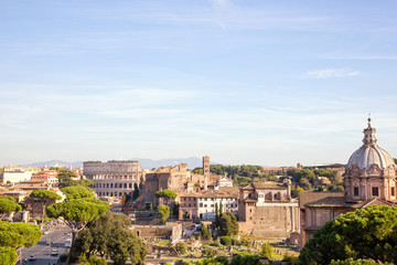 Fototapeta na wymiar Panoramic view over the old city of Rome beautifully lit by an afternoon sun and set against a blue sky.