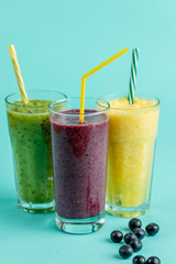 cocktail party. different beverages with straws rainbow from drinks. wellbeing, wellness, fitness concept. yellowm green, purple glasses of cocktail