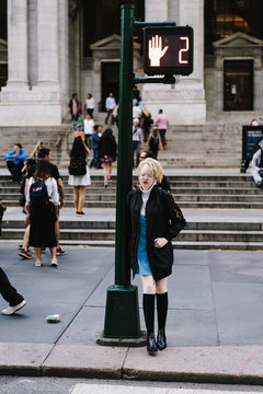 Woman leaning against traffic lights
