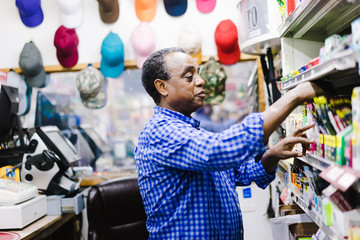 Shopkeeper arranging stationery in the shop