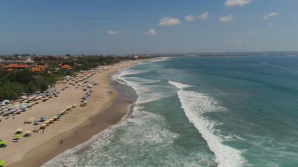 Aerial view sand beach with surfers and tourists, Kuta, Bali. surfers on water surface ocean catch wave. Seascape, beach, ocean, sky sea Travel concept