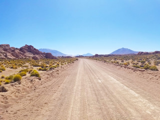 Desert road with mountains in the distance. Rocky mountains