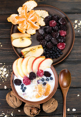 Oatmeal with fruit on a wooden background