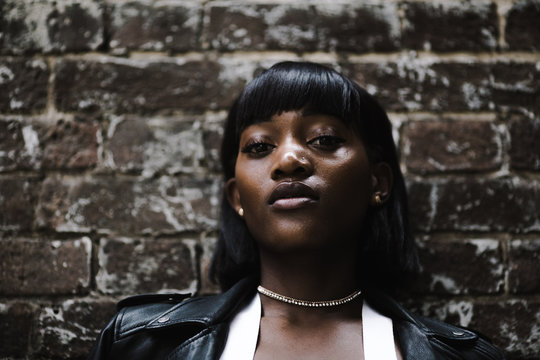 Portrait Of Young Woman Against Brick Wall