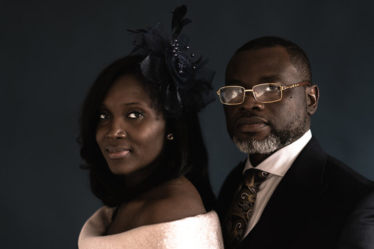 Portrait of couple standing against black background
