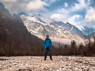 Man in German nature at the center of the Berchtesgaden forest with a clear view to the Watzmann Mountain at the background