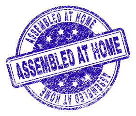 ASSEMBLED AT HOME stamp seal imprint with grunge texture. Designed with rounded rectangles and circles. Blue vector rubber print of ASSEMBLED AT HOME tag with grunge texture.