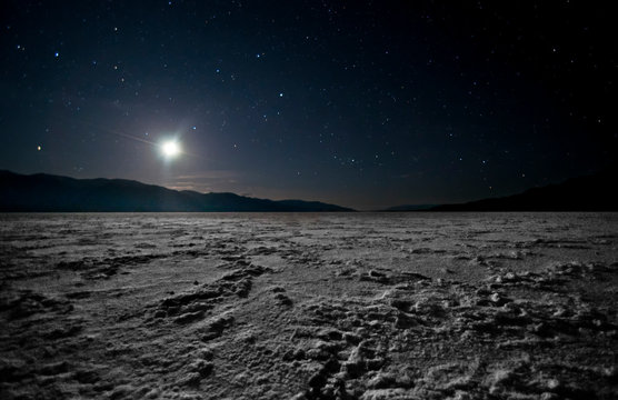 The moon sets in Death Valley NP from Badwater salt flats, lowest point in the US.