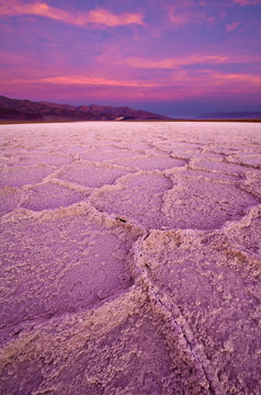 A vibrant pink sunrise turns the salt formations near Badwater in Death Valley pink.