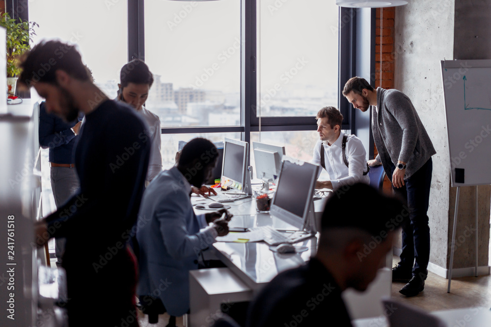 Canvas Prints multi ethnic group of male architectures and web-designers standing randomly in the big spacious ope