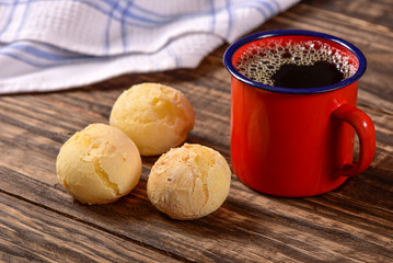 Cheese bread balls and black coffee on wooden background