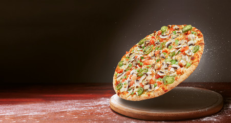 classic pizza on a dark wooden table background and a scattering of flour. pizza restaurant menu...
