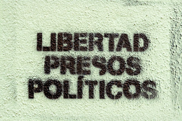 Political graffiti, in the Catalan language, stenciled onto the ground. calling for freedom for political prisoners. in the town of Figueres.