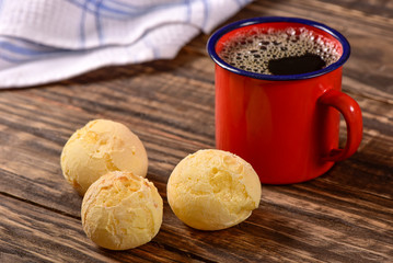 Cheese bread balls and black coffee on wooden background