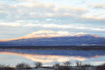 Thingvallavatn lake with reflection of sun during winter near sunrise