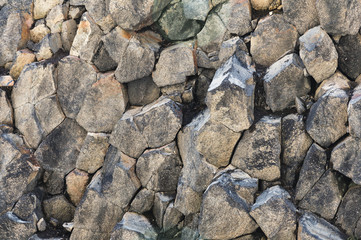 Textured basalt background hexagonal stone pillars in a section. natural volcanic formations