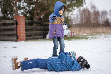 Fototapeta na wymiar Two little boys playing on snow.