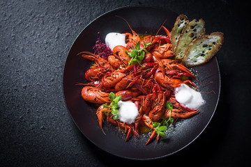 Red boiled crayfishes on black plate
