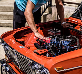 man repairing a classic car