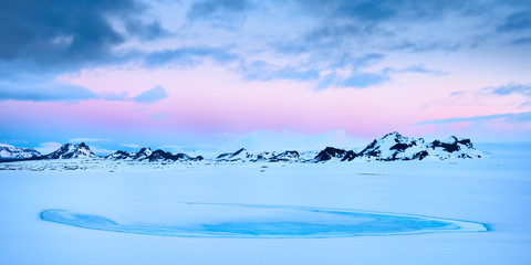 Dawn breaks over the mountains on the edge of the Langjokull glacier in the highlands of Iceland.