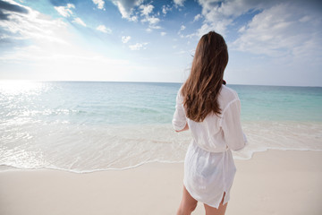 Woman on beach looking at Caribbean Sea, British West Indies