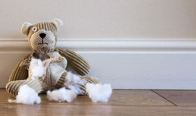Sad, Abandoned and Damaged Teddy Bear with stuffing falling out