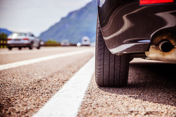 Tyre of a car on the emergency lane, breakdown on the highway. Copy space. 