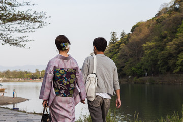 Japanese couple walking by the lake in Arashiyama, Kyoto Japan
