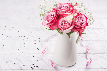 Pink roses in a white pitcher