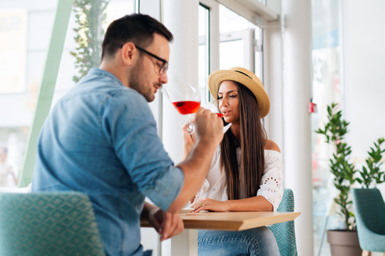Happy couple romantic date drink glass of red wine at restaurant. - Image