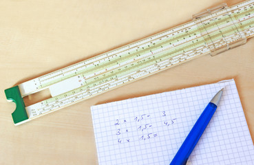 calculating with a slide rule, multiplications written on paper