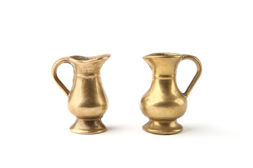 Small golden metal  decorative jugs isolated on white background. Two vintage gold vase pitchers.