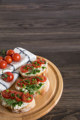 Bruschetta with tomatoes and herbs on a wooden plate, Italian food appetizers