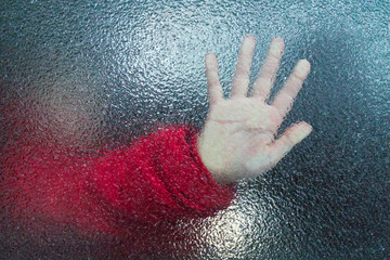 Girl's hand through freezed glass