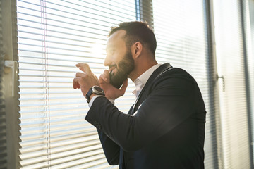 The businessman phones near blind on the window