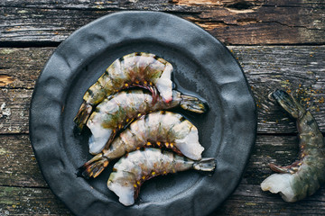 Healthy organic tiger shrimps in a plate on a wooden table top view