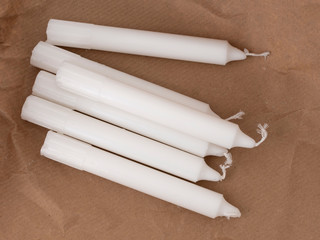 Traditional white household wax candles with brown paper packaging. Emergency lighting electricity...