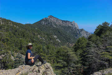 the girl looks at the sea, cedar forest and mountains while walking along the Lycian trail