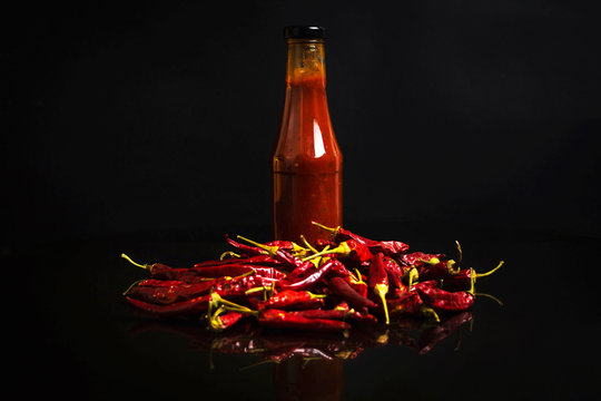 Chilli peppers and bottles of spicy sauce