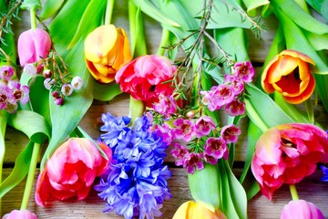 Fototapeta na wymiar Frühling Blumenstrauß - Frühlingsblumen Tulpen und Hyazinthen auf Holzbrett