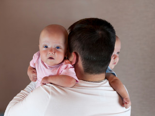 Young father with his newborn twins. Selective focus.