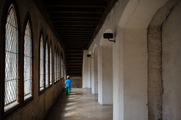 a 6-year boy at the end of a corridor in a castle