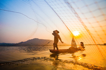 Fisherman on boat river sunset Asia fisherman net using on wooden boat casting net sunset or...