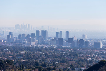 Smoggy morning cityscape view towards Century City and downtown Los Angeles from hiking trail in...