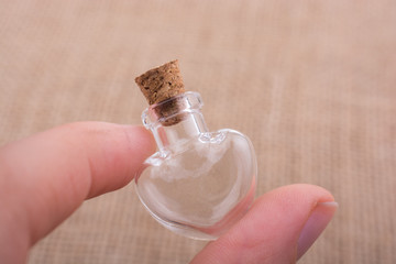 Heart shaped glass bottle in hand
