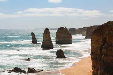 Close up of the Twelve Apostles rock formation on a hot summer day with white clouds and a light sea breeze (Great Ocean Road, Victoria, Australia)