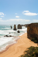 World famous Twelve Apostles rock formation on a hot summer day with white clouds and a light sea breeze (Great Ocean Road, Victoria, Australia)
