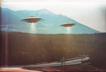 Unidentified flying object. Two UFOs flying over a road among the trees. 3D illustration retro...