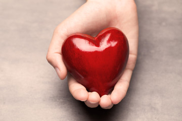 Fototapeta premium Red wood heart in child hands