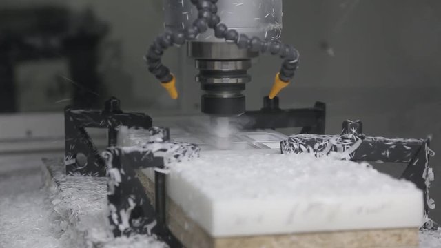 Industrial cnc drill is drilling a detail in to the plastic plank